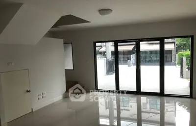 Spacious modern living room with large windows and glossy floors