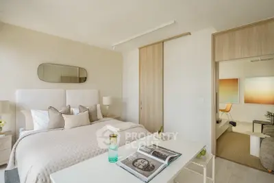 Elegant bedroom with modern decor and sliding doors leading to a cozy living area.