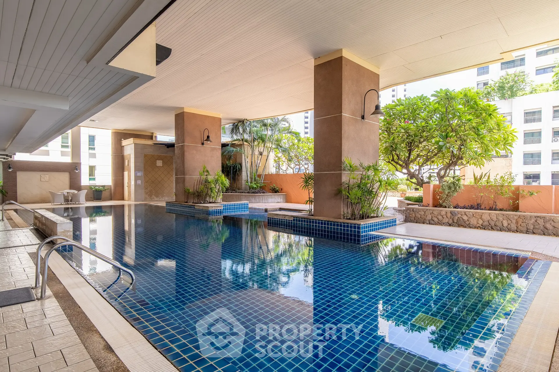 Luxurious indoor pool area with modern design and lush greenery in a high-end residential building.