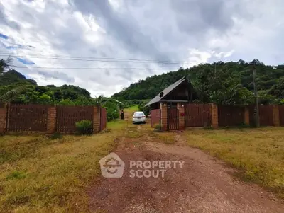Charming countryside property with rustic wooden fence and lush greenery