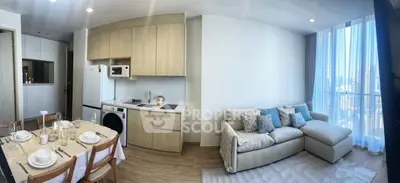 Modern open-plan living room and kitchen with city view and elegant dining setup.