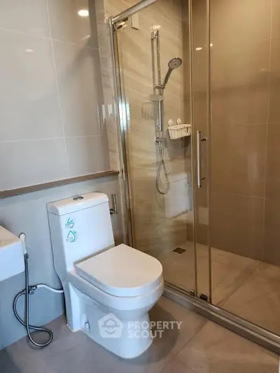 Modern bathroom with sleek shower and toilet in contemporary apartment.