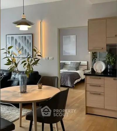 Modern open-plan living room and kitchen with stylish decor and cozy bedroom view.
