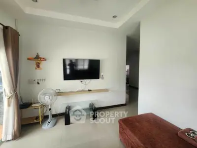 Modern living room with wall-mounted TV and sleek glass table