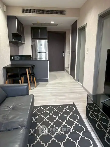 Modern apartment interior with sleek kitchen and cozy living area, featuring stylish furniture and contemporary design.