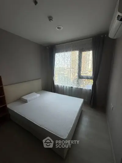 Cozy bedroom with large window and air conditioning in modern apartment