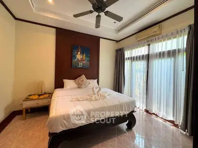 Spacious bedroom with elegant decor and large windows for natural light.