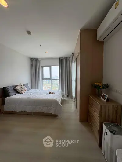 Spacious bedroom with city view, modern furnishings, and ample natural light.