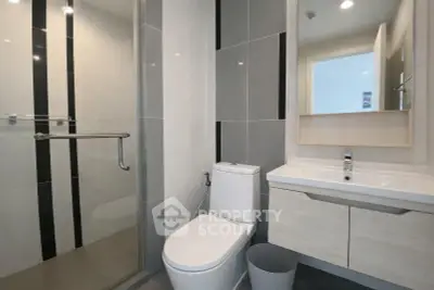 Modern bathroom with sleek design and glass shower enclosure in contemporary apartment.