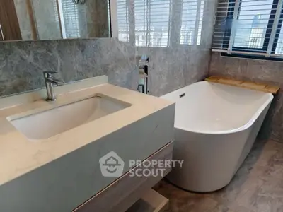 Luxurious bathroom with modern freestanding bathtub and elegant marble finishes.
