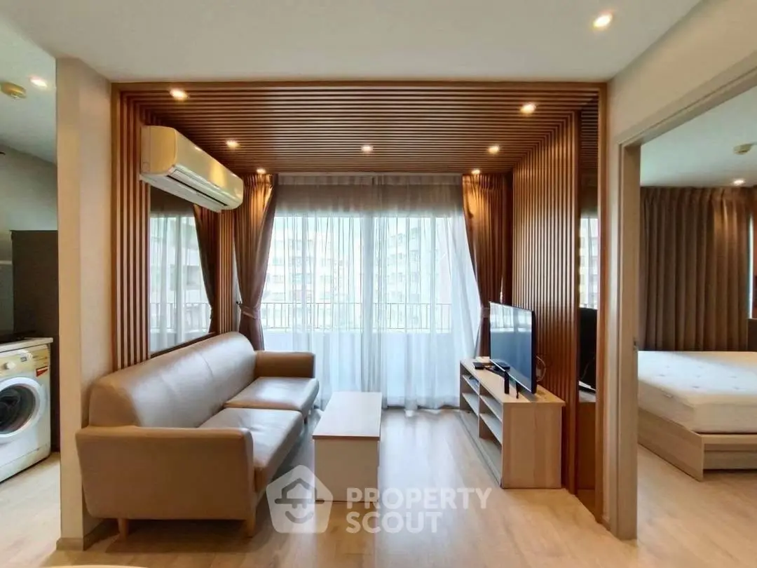 Modern living room with wooden accents and natural light, featuring a cozy sofa and flat-screen TV.