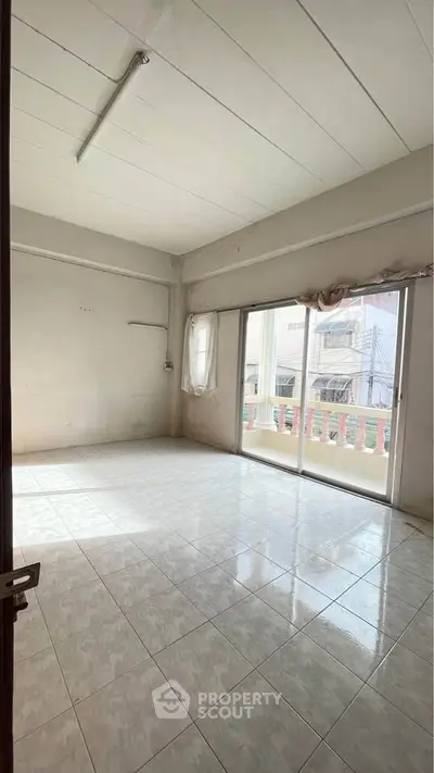 Spacious unfurnished room with large windows and balcony access, ideal for customization.