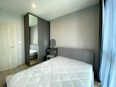 Modern bedroom with large window and sleek furniture in a stylish apartment.