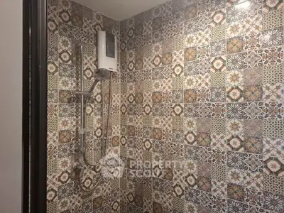 Stylish bathroom with intricate patterned tiles and modern shower setup.