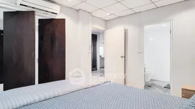 Cozy bedroom with modern decor and ensuite bathroom in a stylish apartment.