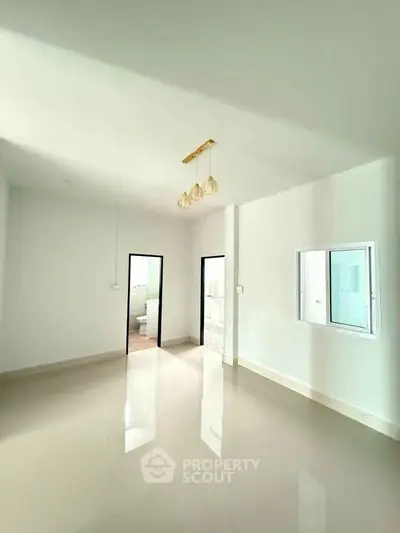 Spacious modern living room with glossy floors and elegant lighting in a minimalist home.