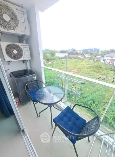 Charming balcony with seating and lush green view, perfect for relaxation.