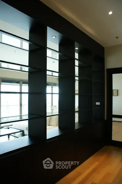 Modern living room with sleek black shelving and hardwood floors