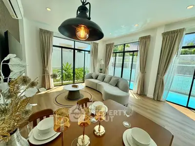 Luxurious living room with pool view, elegant decor, and abundant natural light.
