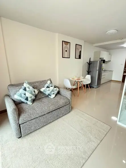 Modern living room with cozy sofa and stylish kitchen in open layout apartment.