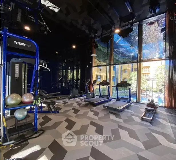 Modern gym with state-of-the-art equipment and large windows offering a scenic view.