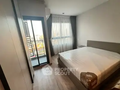 Modern bedroom with large window and balcony view in urban apartment