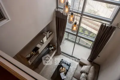 Stunning loft-style living room with floor-to-ceiling windows and modern decor.