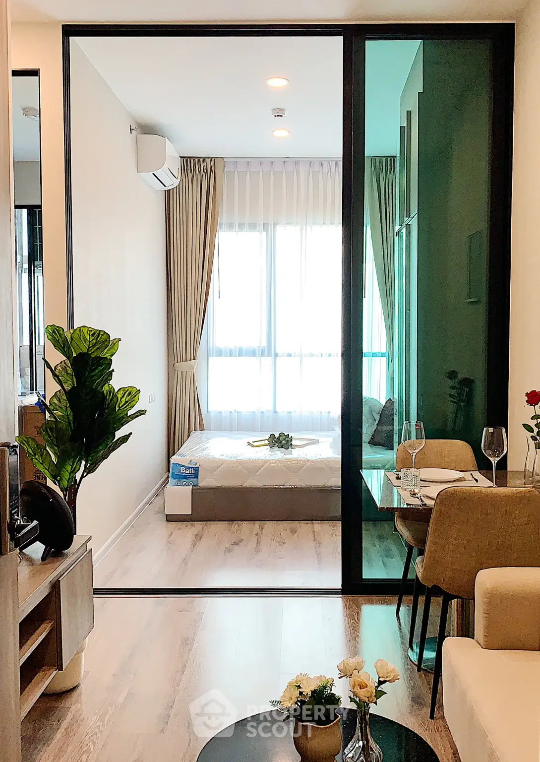 Modern apartment interior with open living room and bedroom, featuring elegant decor and natural light.