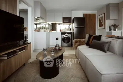 Modern living room with sleek kitchen, stylish decor, and cozy seating area.
