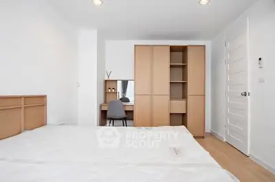 Spacious bedroom with modern wooden furniture and ample natural light