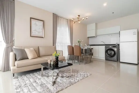 Modern open-plan living room with kitchen, featuring sleek furniture and appliances.