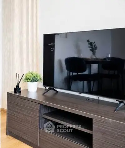 Modern living room with sleek TV stand and large flat-screen TV, perfect for entertainment.