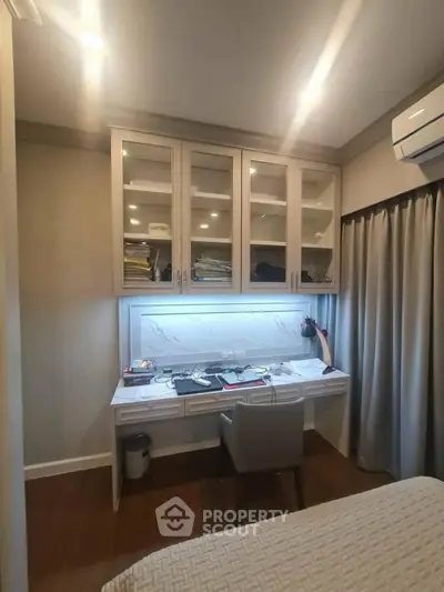 Modern study room with built-in desk and cabinets, featuring ambient lighting and sleek design.