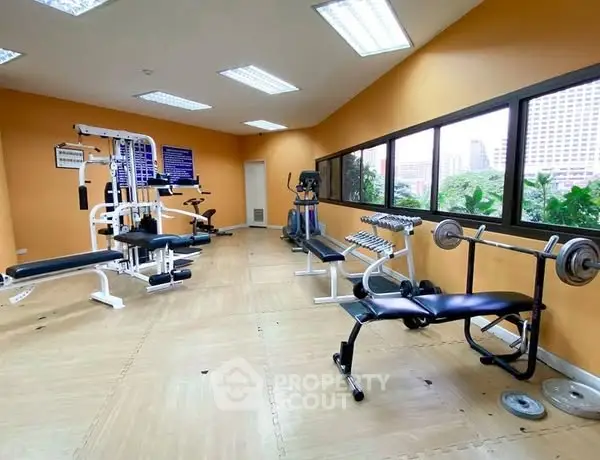 Spacious gym with modern equipment and city view windows