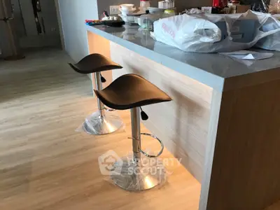 Modern kitchen with stylish bar stools and wooden flooring