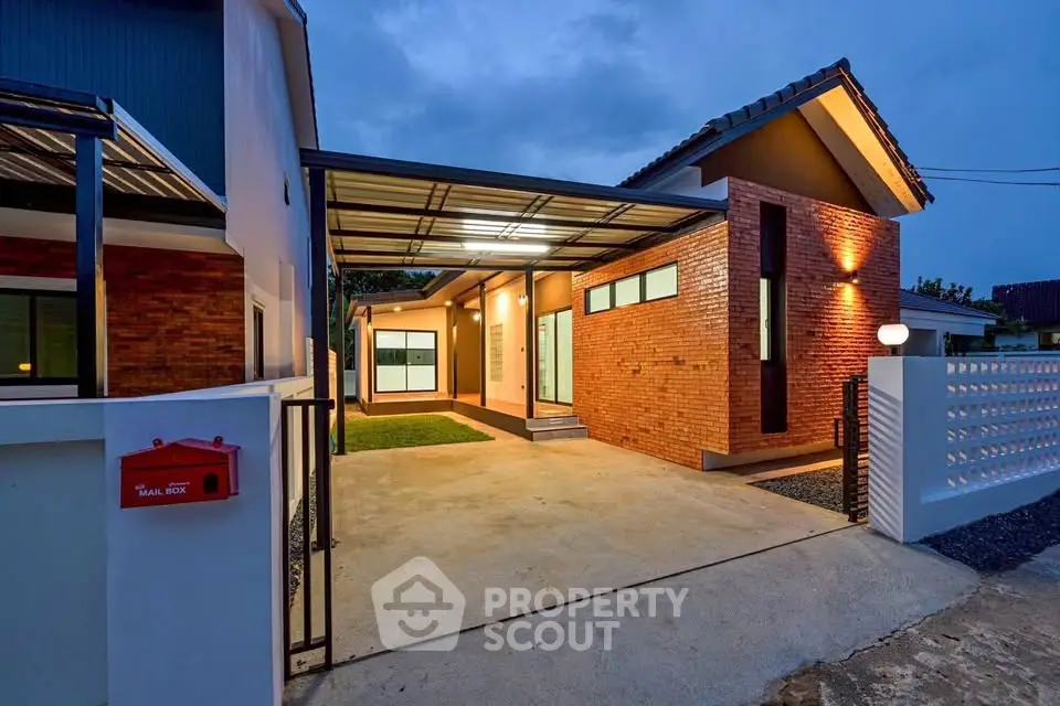 Modern single-story house with brick facade and spacious driveway at dusk.