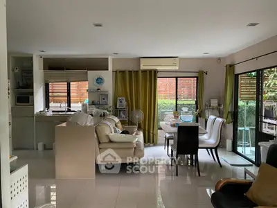 Spacious open-plan living and dining area with modern kitchen and garden view.