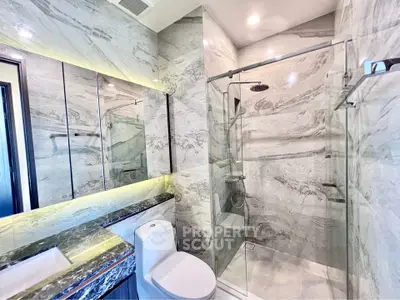 Luxurious modern bathroom with marble walls and glass shower enclosure