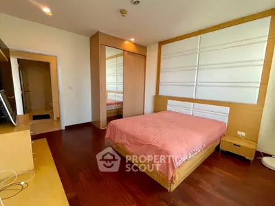 Spacious bedroom with wooden flooring and modern design in a luxury apartment.