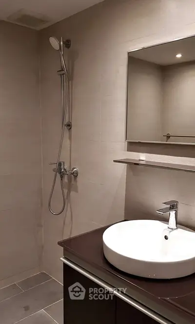 Modern bathroom with sleek fixtures and elegant design, featuring a stylish sink and shower area.