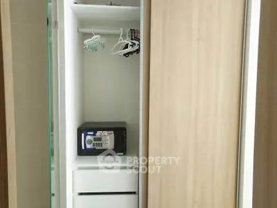 Modern closet with built-in safe and hangers in a stylish apartment