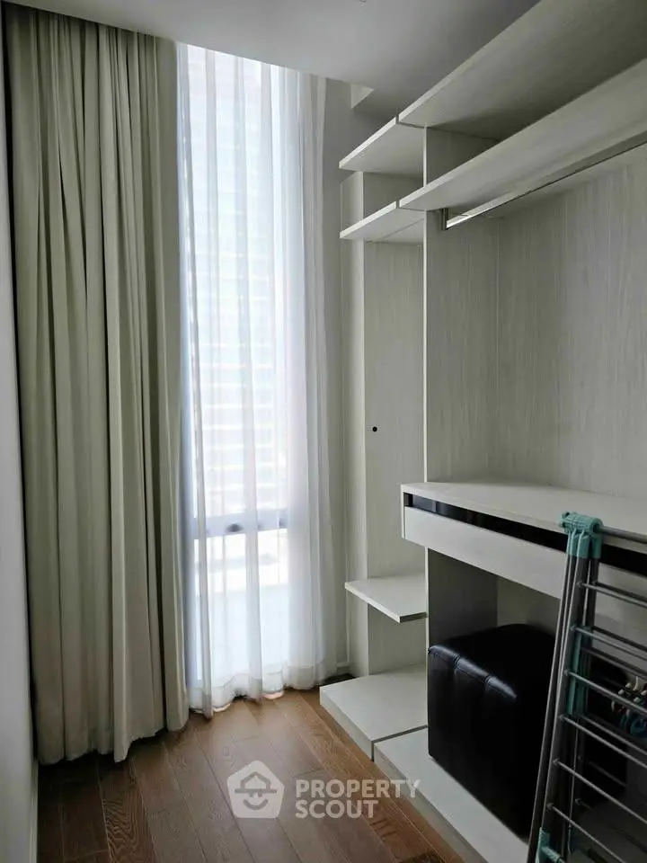 Modern storage space with natural light and sleek shelving in a contemporary apartment.