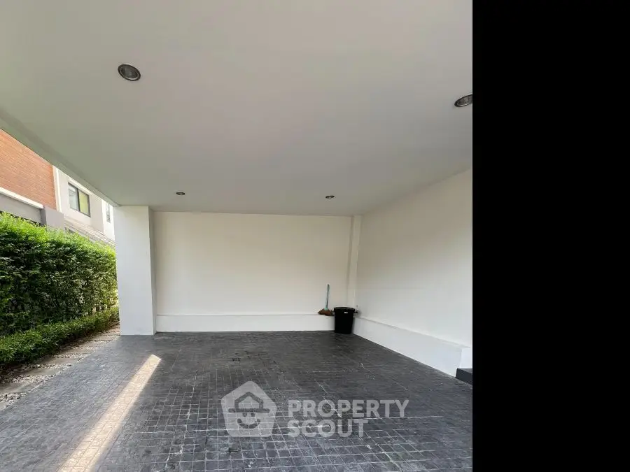Spacious covered parking area with modern design and natural lighting.