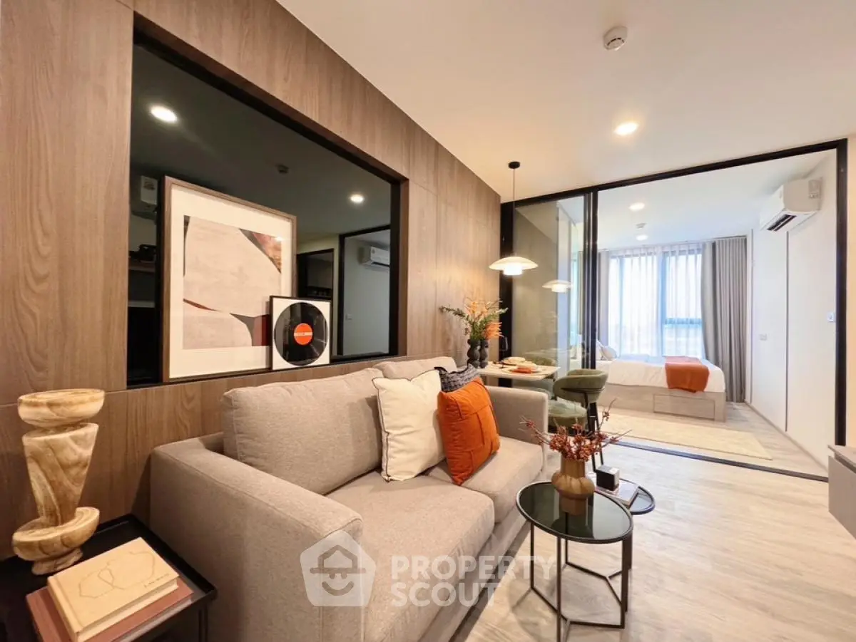 Modern living room with stylish decor and open layout leading to bedroom