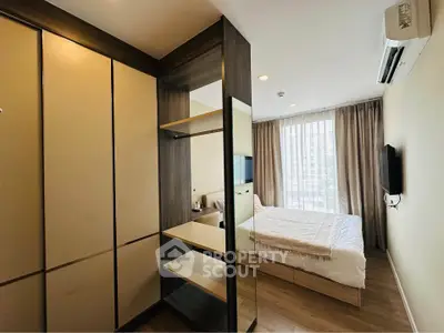 Modern bedroom with sleek design, featuring a large window, built-in wardrobe, and wall-mounted TV.