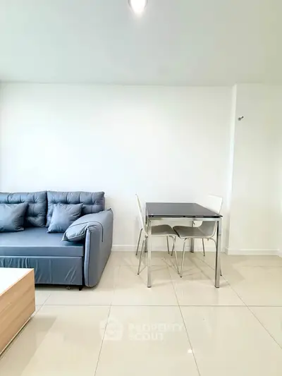 Modern living room with sleek furniture and minimalist design, featuring a cozy sofa and dining table.