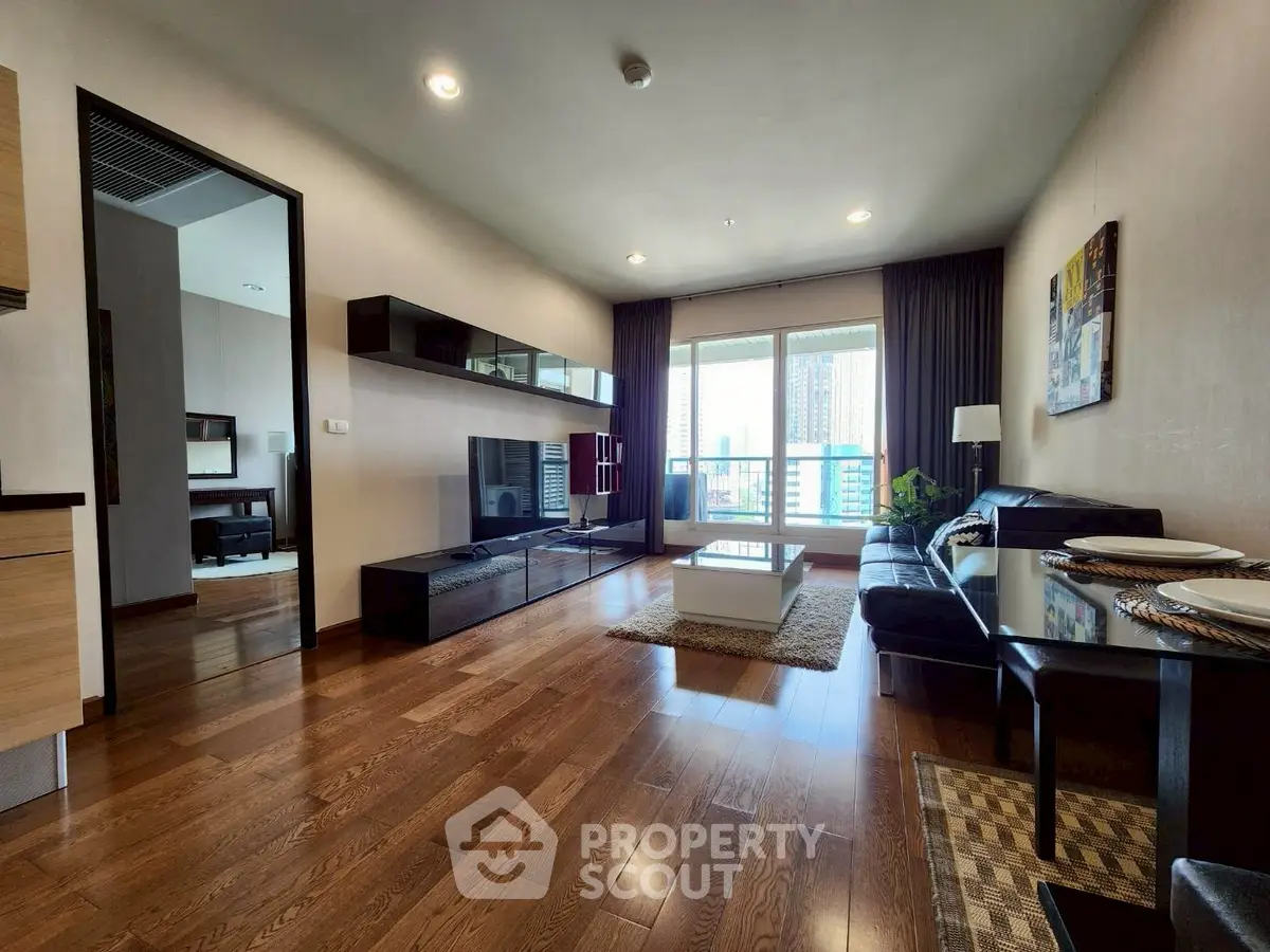 Spacious modern living room with hardwood floors and large windows in a luxury apartment.