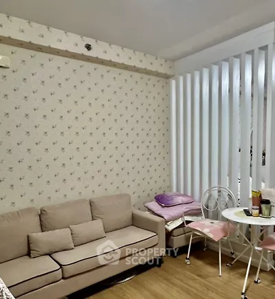 Cozy living room with floral wallpaper and beige sofa, perfect for relaxation.
