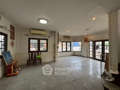 Spacious living room with large windows and marble flooring, ideal for family gatherings.