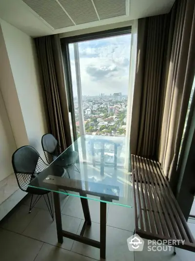 Modern dining area with glass table and city view from high-rise apartment